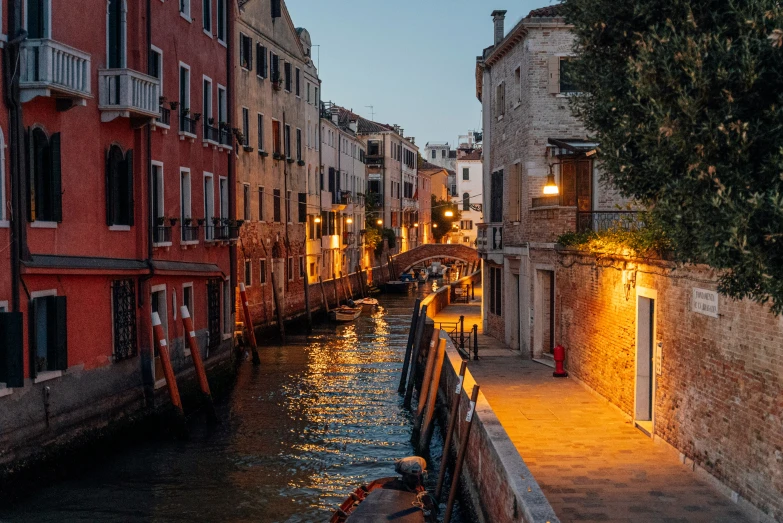 a narrow canal runs between buildings at dusk