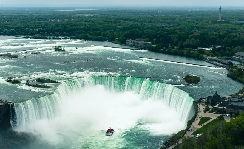 a boat in the water by a waterfall