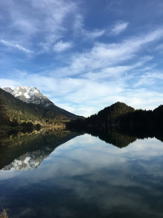 mountain lake surrounded by trees and mountains with clear water