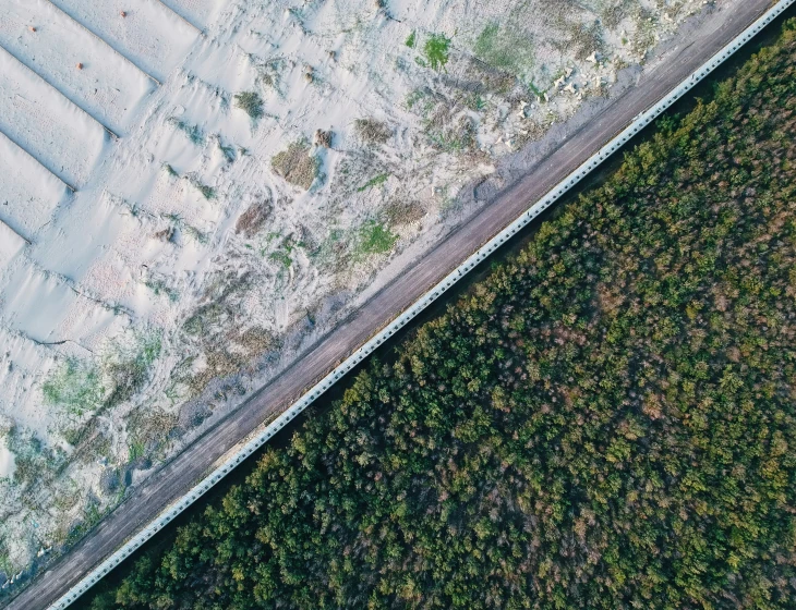 an aerial view of grass and snow on a path