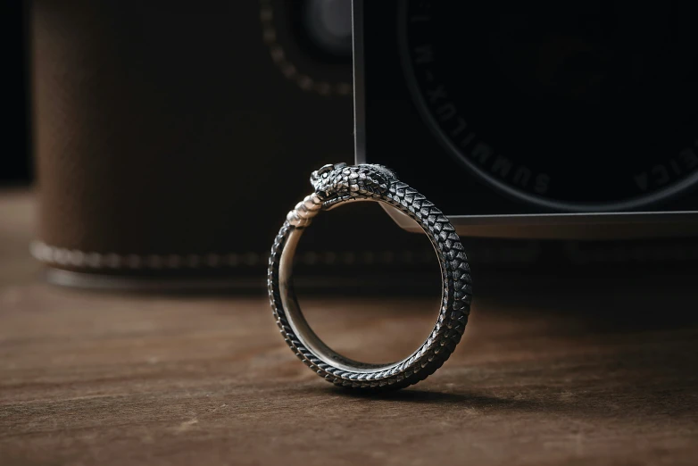 a diamond ring sitting on a table next to an old - fashioned camera