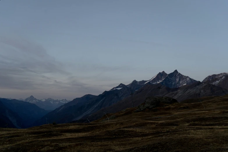 snow capped mountains stand on the horizon at dusk