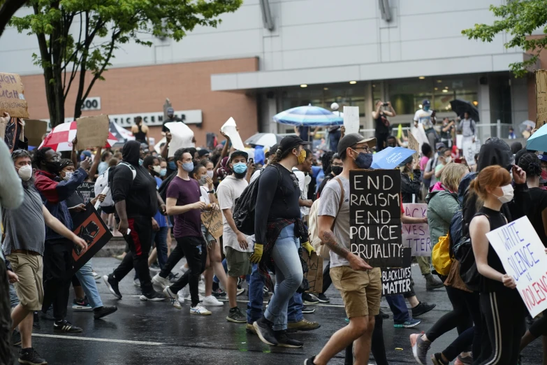 a crowd of people marching down the street in a protest