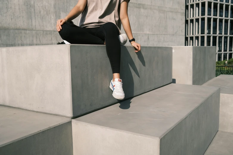 a girl sits at the edge of concrete blocks