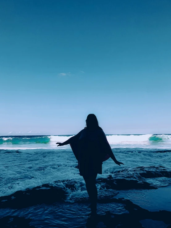 a person is walking out into the ocean with their surfboard