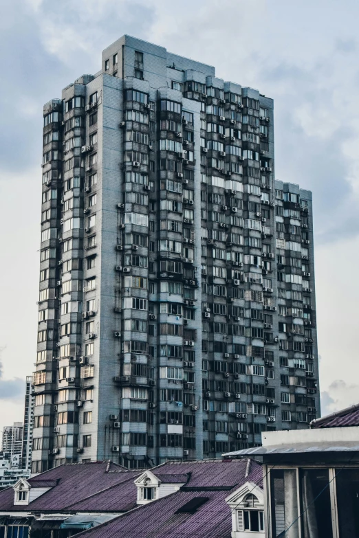 a tall building with several windows surrounded by rooftops