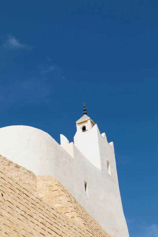 an old white building with an elaborate roof and bell