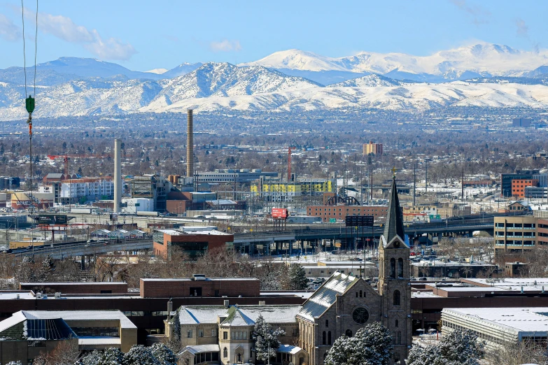 snowy mountains in the background of a city
