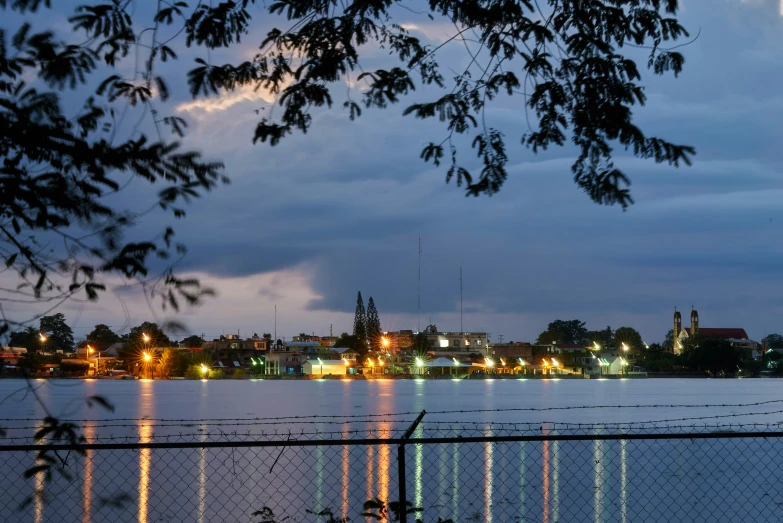 the city lights shine brightly at night near a lake