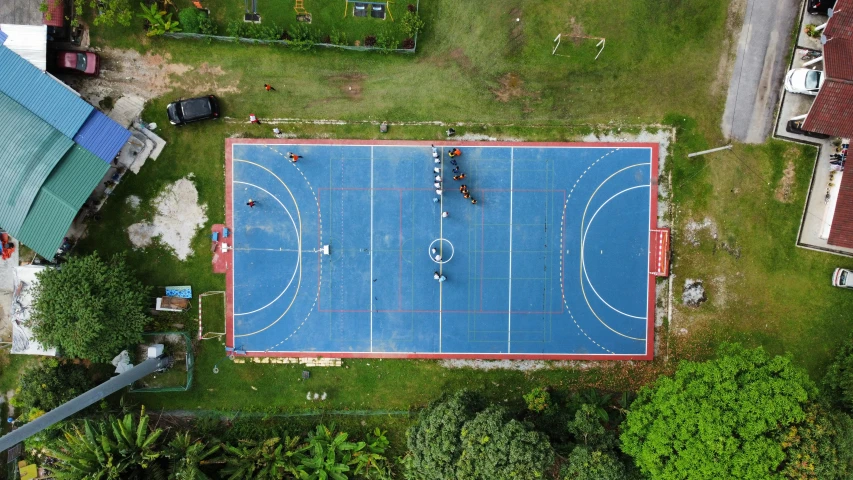 aerial view of an outdoor sports court in an overgrown yard