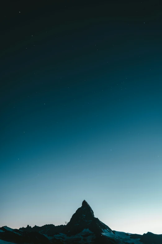 the silhouette of a mountain is shown against the night sky