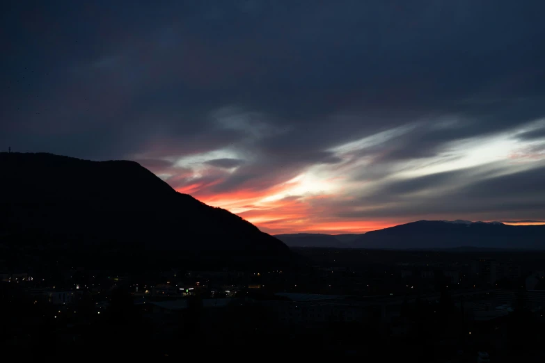 a sunset view of a mountain and clouds