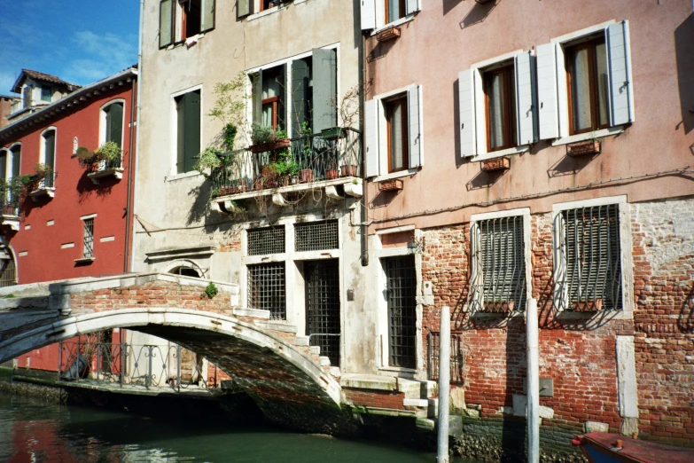 a small bridge going over a canal next to tall buildings