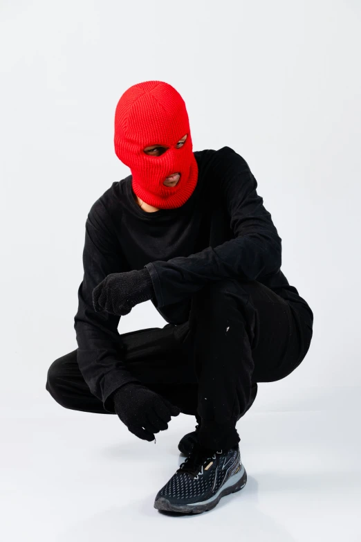 a young man wearing a red ski mask