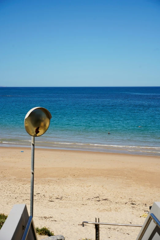 there is an object that is standing in the sand at the beach