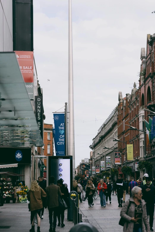 people on a city street with buildings and tall poles