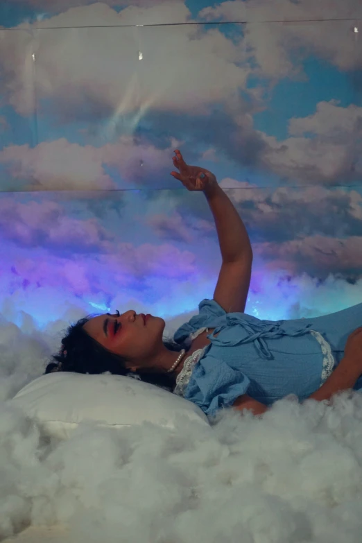 a girl laying on the clouds in a fake sky