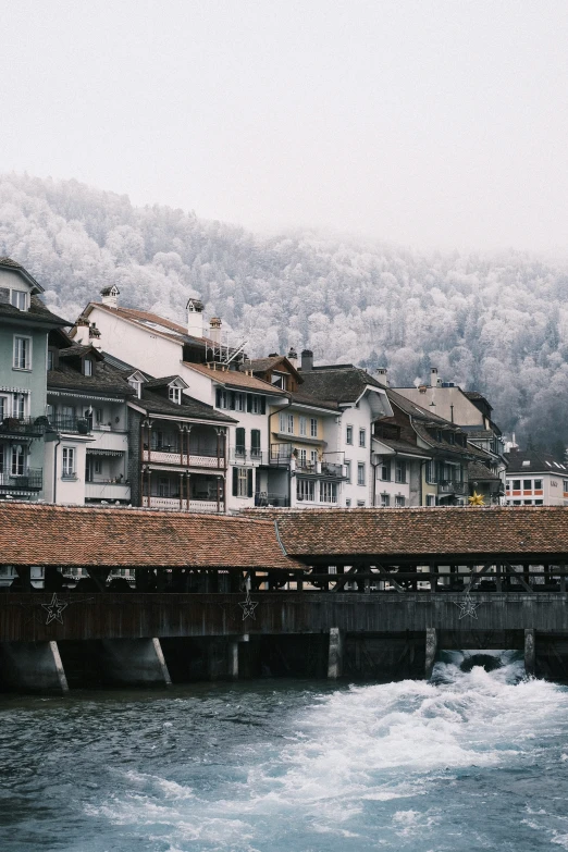 a long bridge with houses on each side and a mountain range in the distance