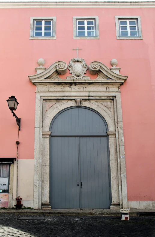 a building with two doors and an iron gate