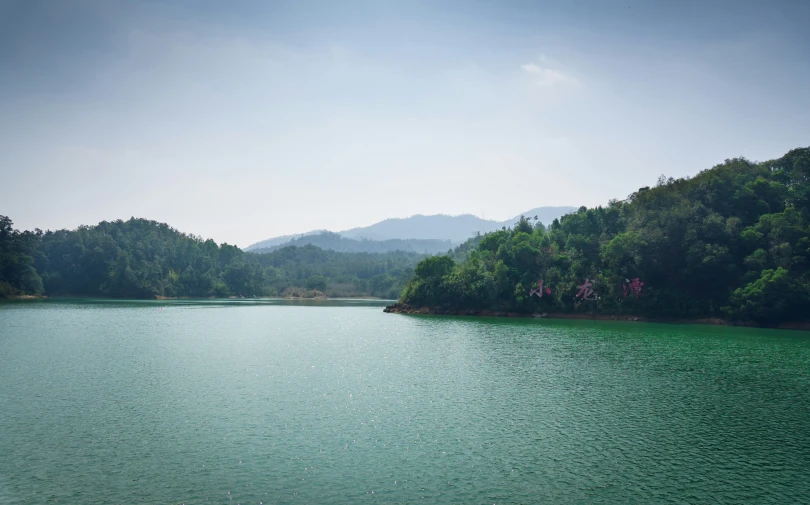 a large body of water sitting next to green trees