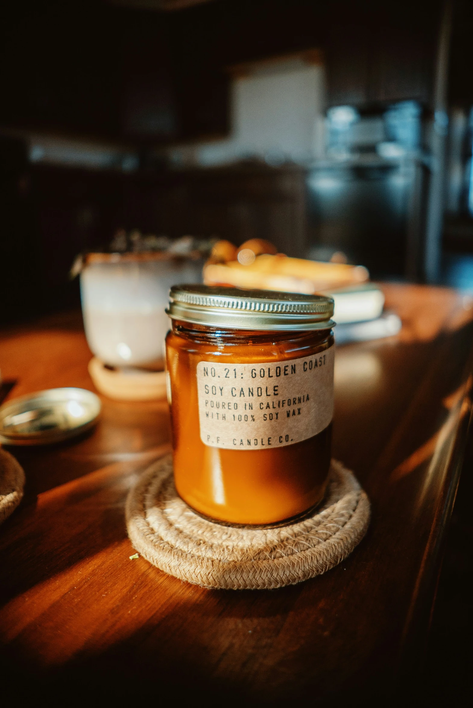 a glass jar on a wooden surface with spoons next to it