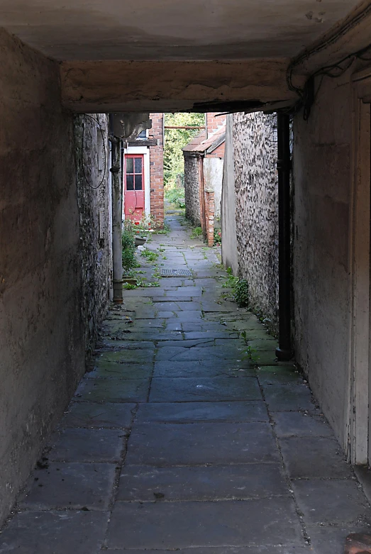 an alley with stone and cobblestone flooring in a rural area