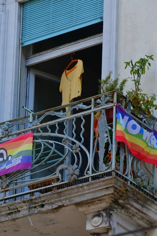 an open balcony with clothes hanging on a rainbow flag