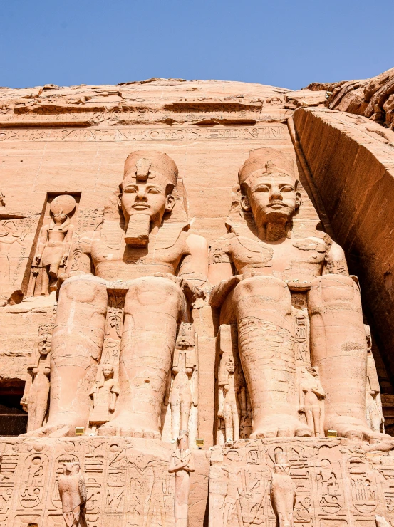 some large statues next to a tall stone building