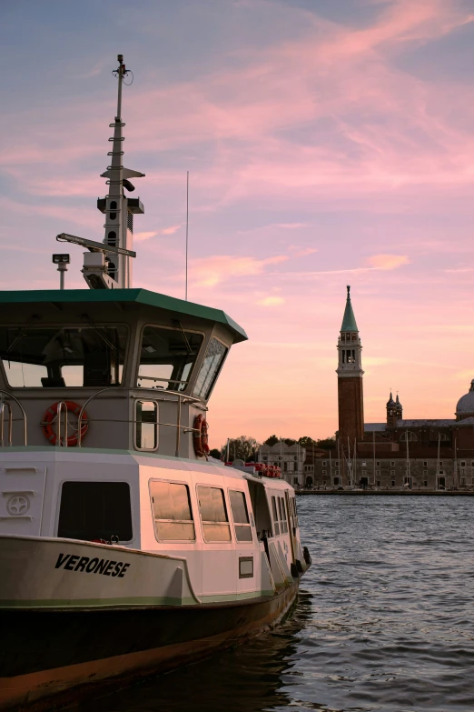 this boat is moored at the dock, looking over the water at the clock tower in the background