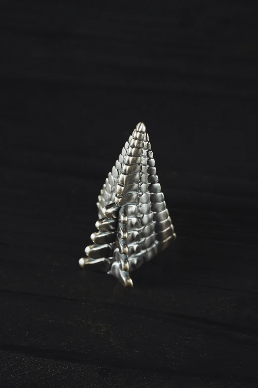 a silver metal christmas tree is shown on a table