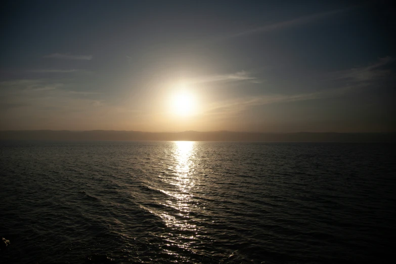the sun is shining above water off a ferry