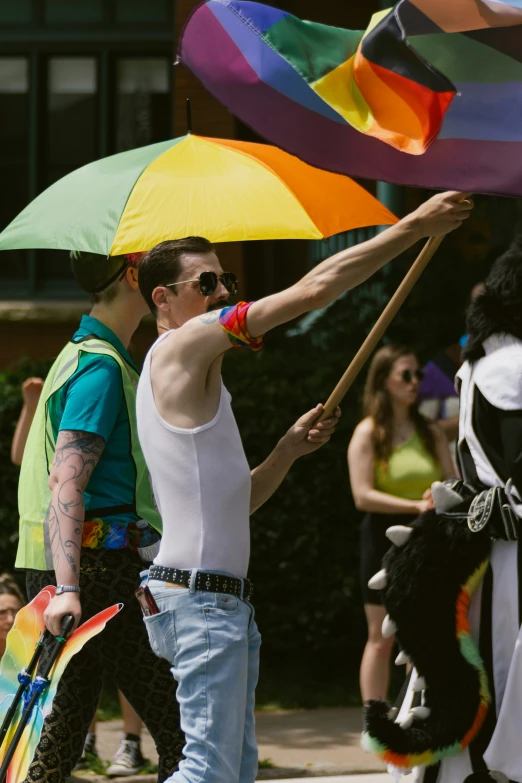 there is a man holding onto some multicolored umbrellas