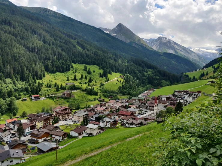 village surrounded by green mountain tops on sunny day