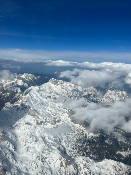 the top view from an airplane shows some snow capped mountains