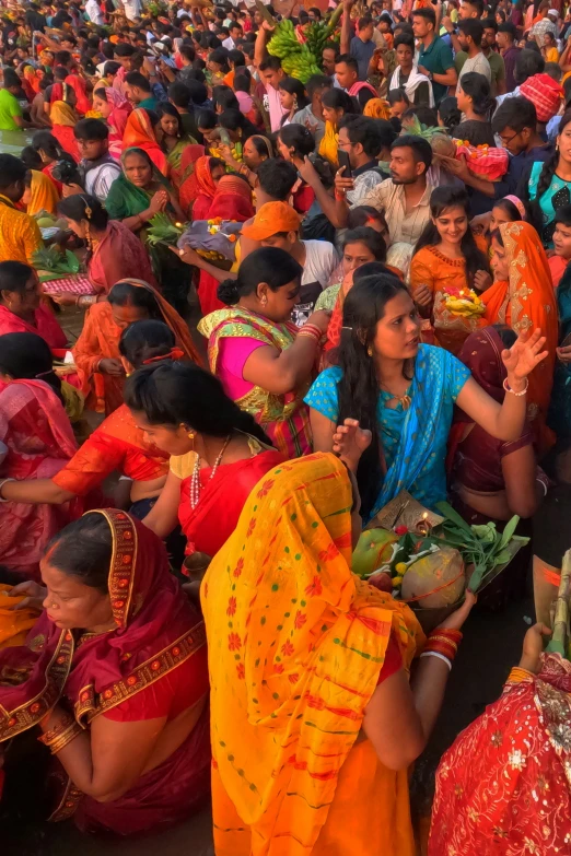 large group of women dressed in colorful saris sitting and praying