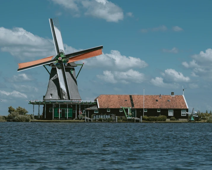 a large white windmill sitting over the top of a river