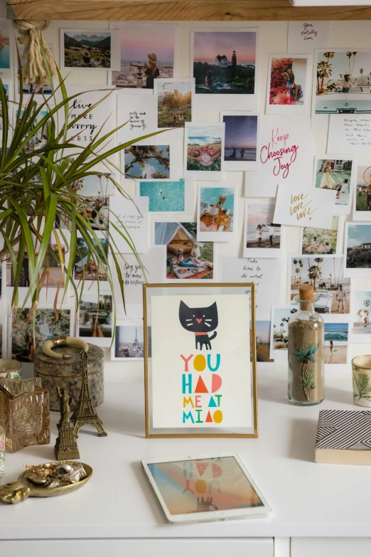 a table topped with a picture frame filled with pos and pictures