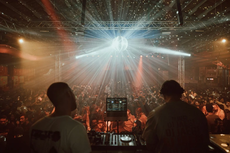 the djs perform at a night club with colorful lights