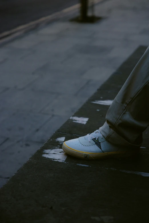 there is a man standing on the street in his sneakers