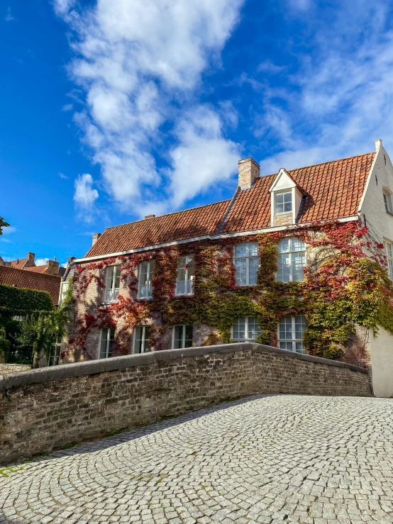 a bricked building on a cobblestone path with vines growing around it