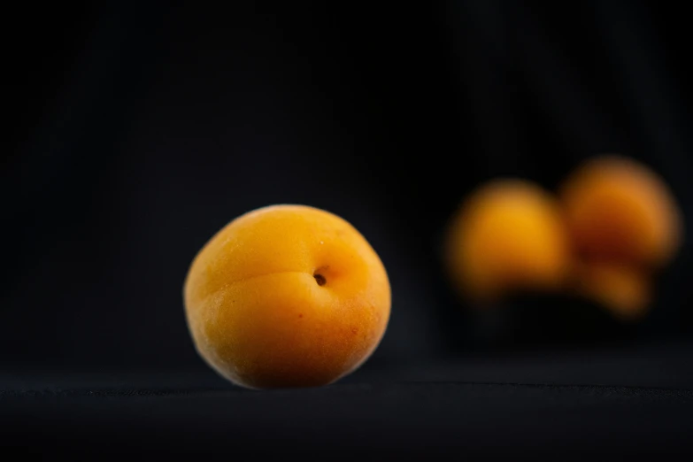 three oranges laying in the dark on the floor