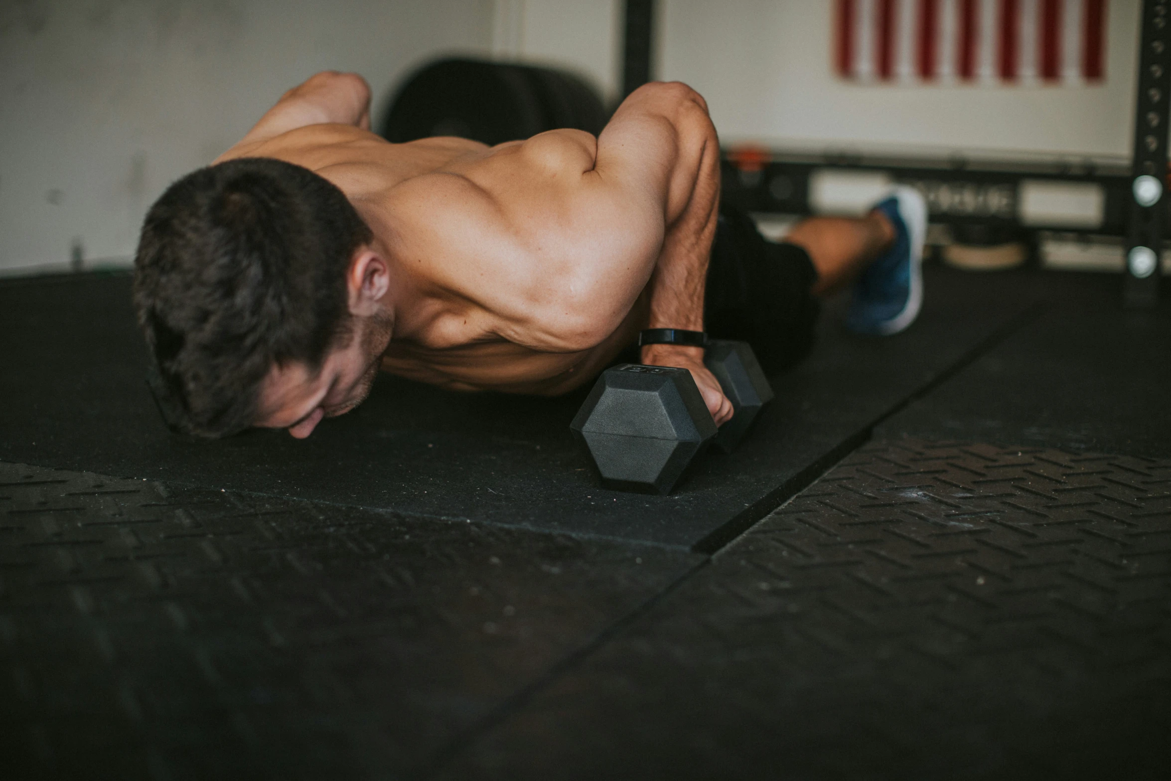 a shirtless man doing h ups on a exercise mat