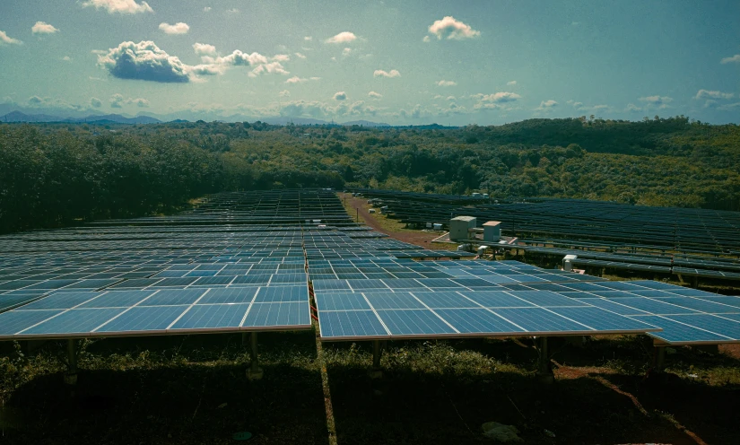 an aerial po of solar power plant with mountains in the background