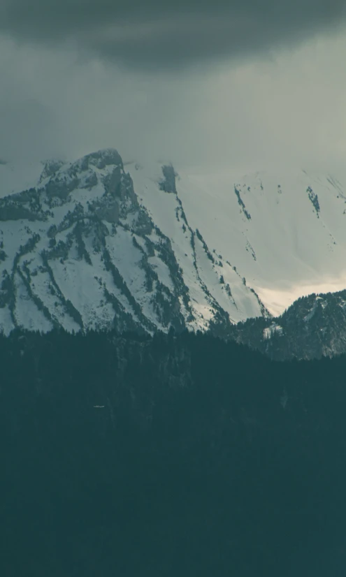 a airplane flying over the top of a mountain