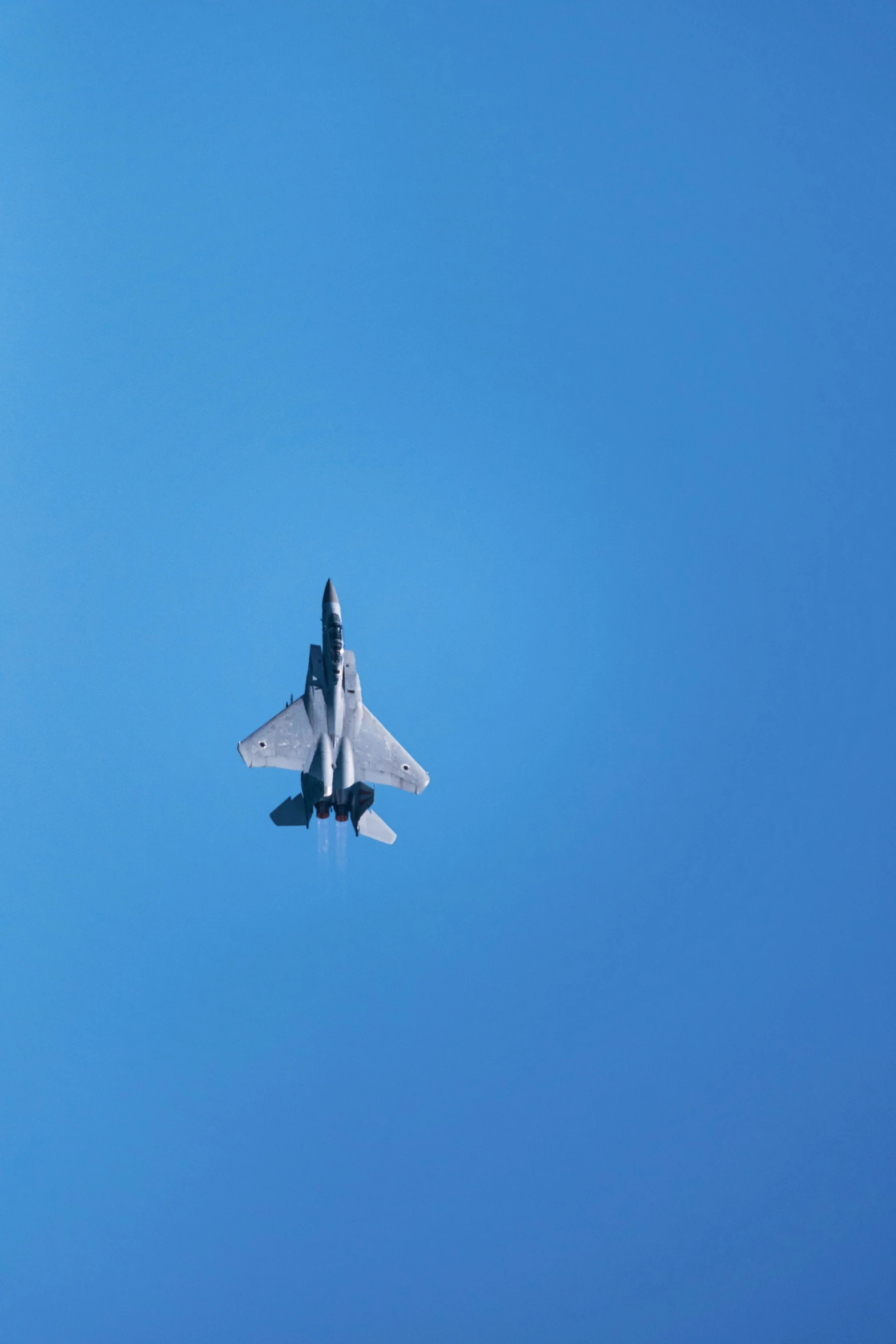 the jet is flying through a clear blue sky