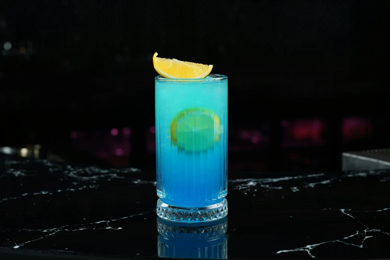 a blue drink with a slice of lemon on the rim
