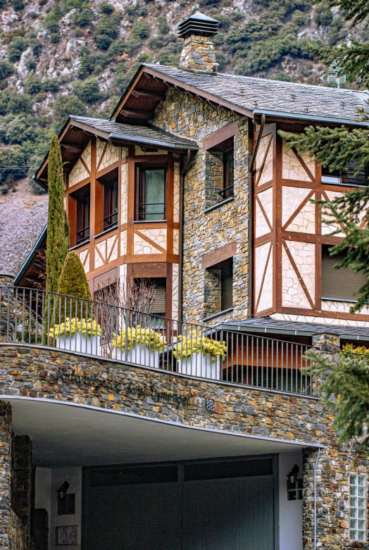 the house is surrounded by greenery and has two cars parked outside