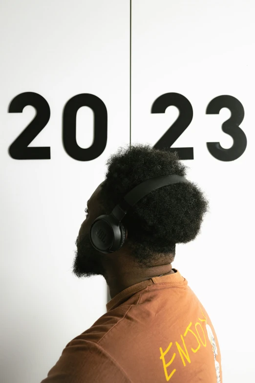 a man with headphones in front of a sign