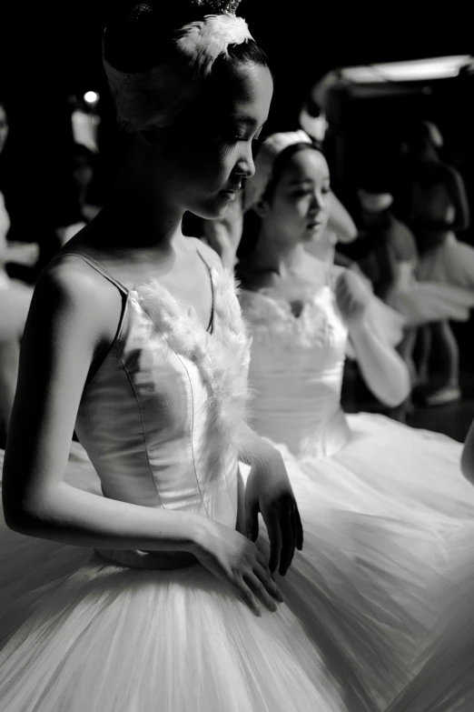 three young women in formal attire stand and look at soing