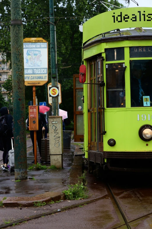 an old trolly is going down the street in the rain